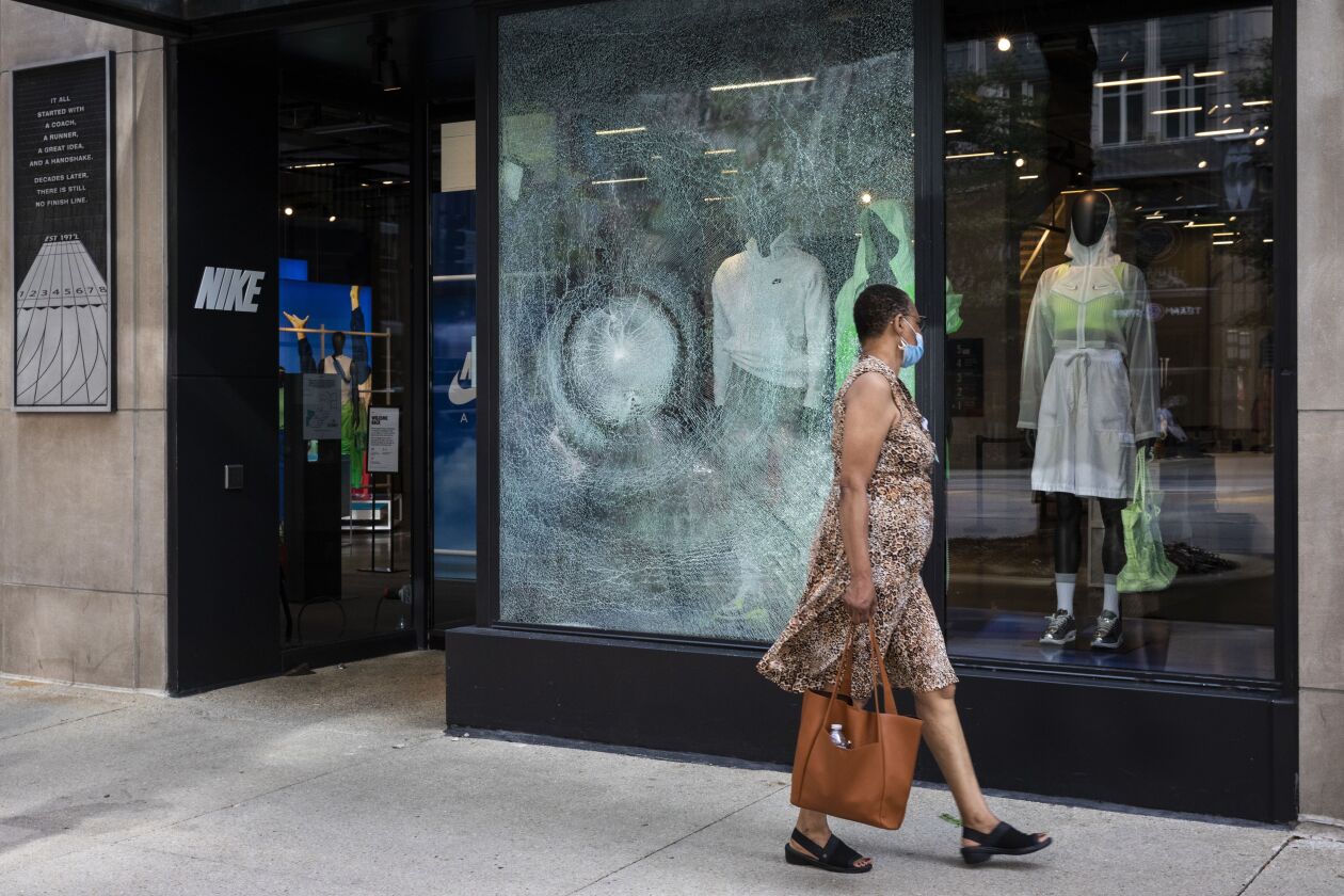 A woman walks past Nike at 669 N. Michigan Ave. on the Magnificent Mile after looting broke out overnight in the Loop and surrounding neighborhoods, Monday morning, Aug. 10, 2020.